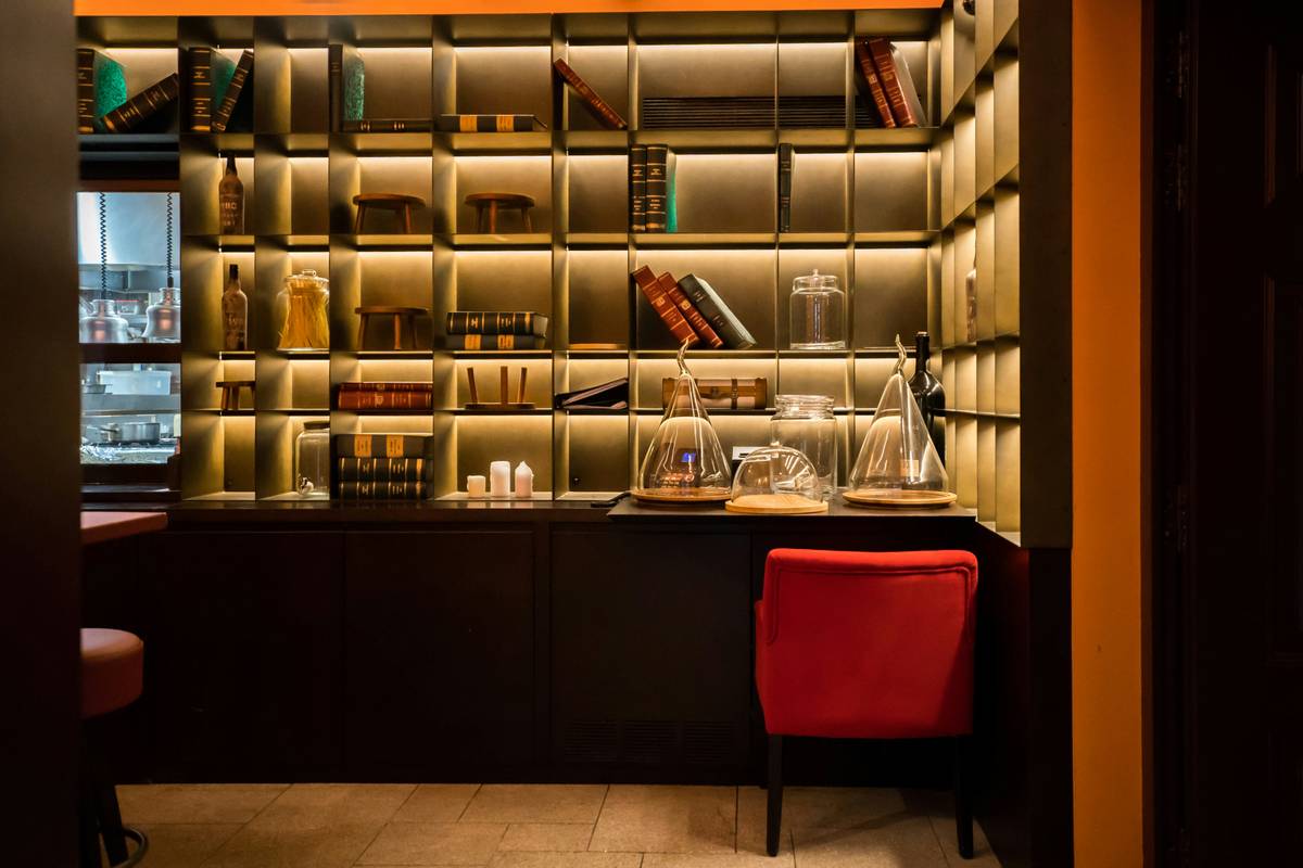 Diagram showing layered lighting zones in a home bar: ambient cove lighting (top), task lighting under cabinets (middle), and accent lighting behind bottles (bottom), all controlled via a central smart hub