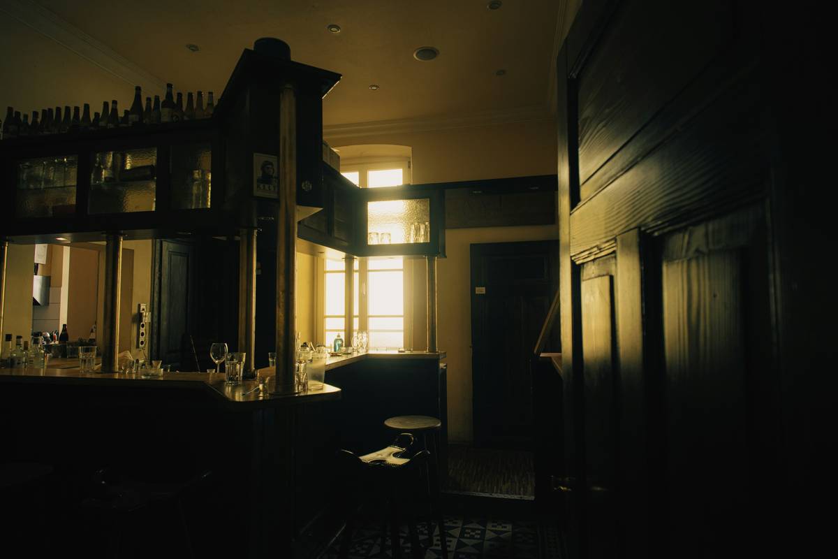 Diagram showing three layers of bar lighting: ambient (wall sconces), task (under-cabinet LEDs), accent (pendant over bar)