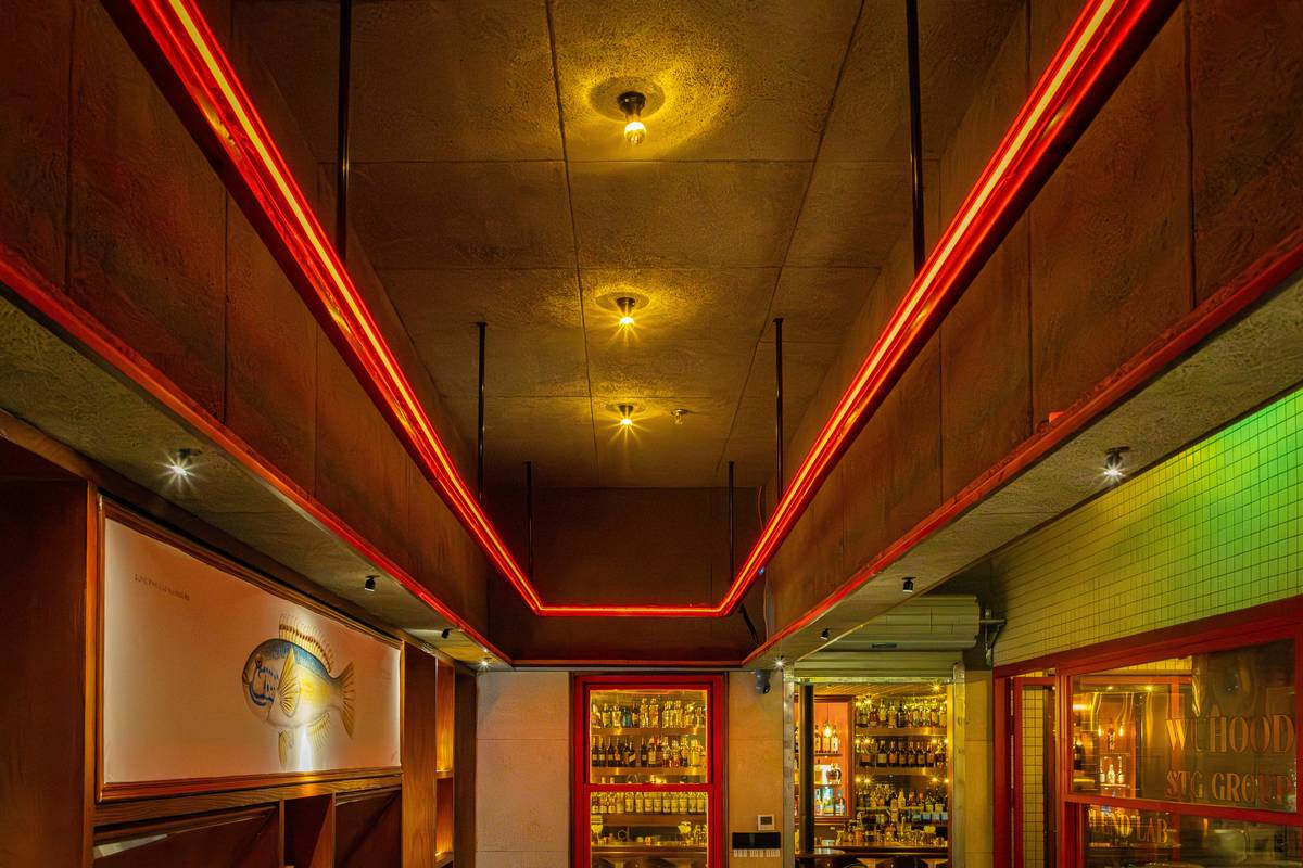 Diagram showing angled LED track lights illuminating bottles, countertops, and seating areas in a home bar with labeled zones and suggested light temps