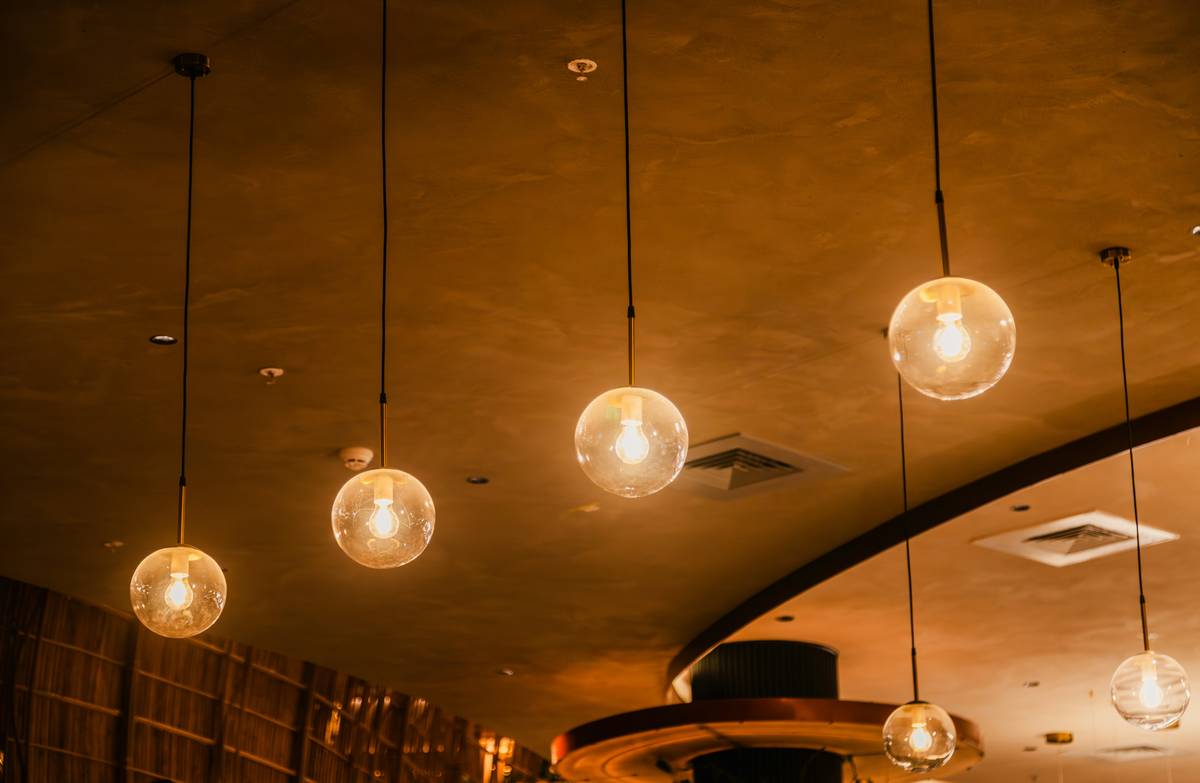 Diagram showing three layers of bar lighting: ambient (ceiling), task (under-cabinet), and accent (shelf backlighting)