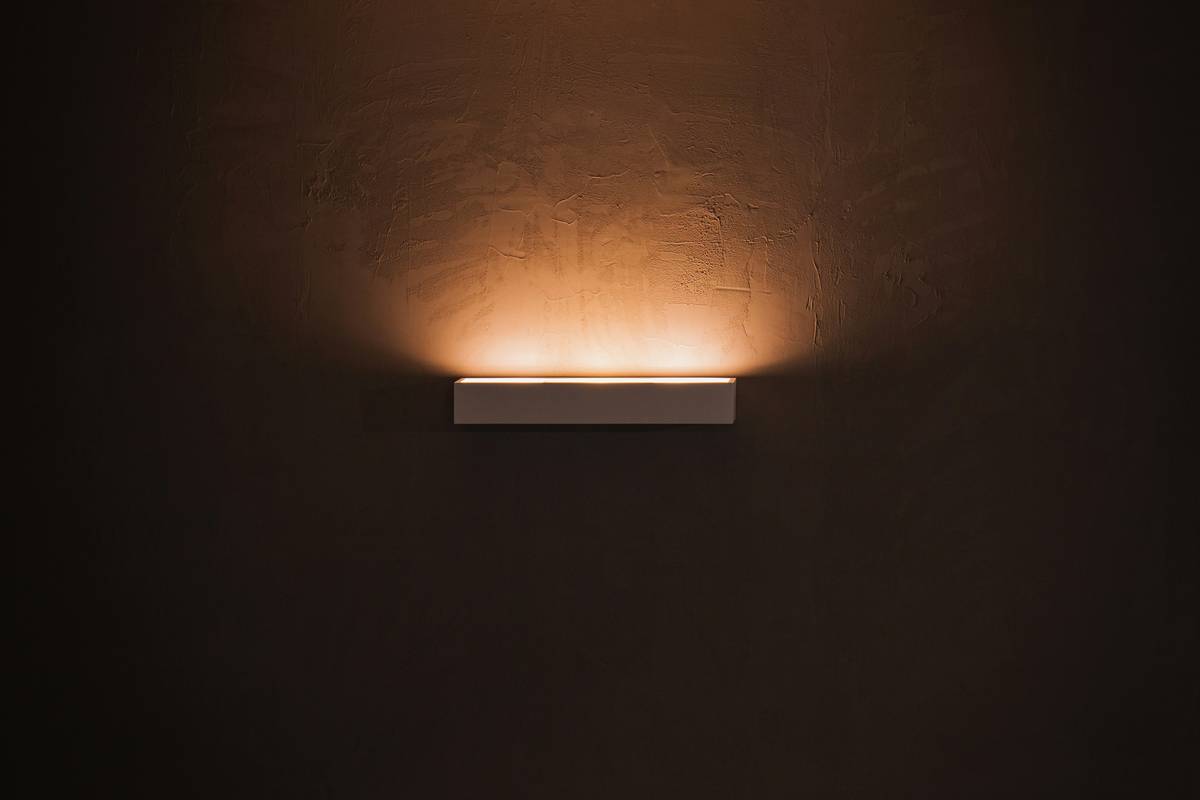 Side-by-side comparison: harsh overhead lighting vs. warm, focused LED dimmable light bar under bar shelf