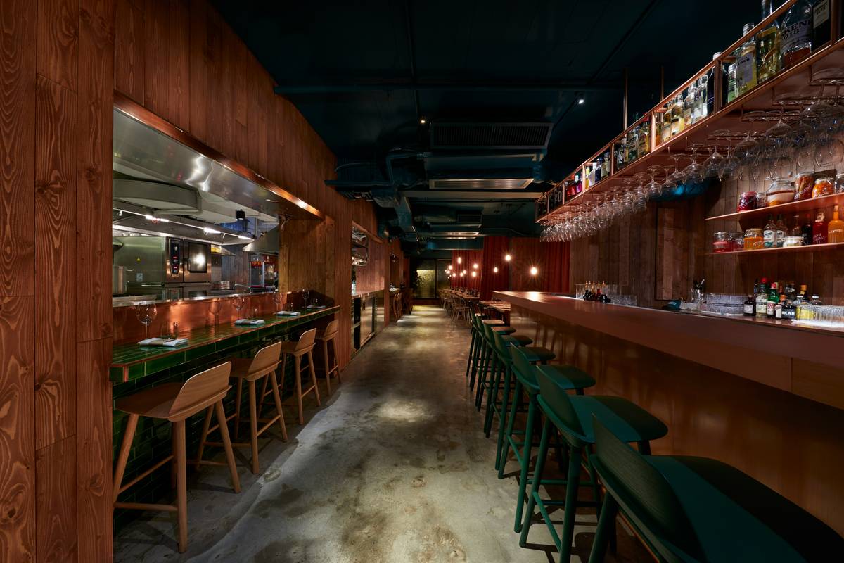 Side-by-side comparison: left shows a home bar lit with harsh overhead lighting casting dark shadows on bottles; right shows the same bar enhanced with warm white RGB LED bar lights under the counter and behind backlit shelves, creating depth and warmth.