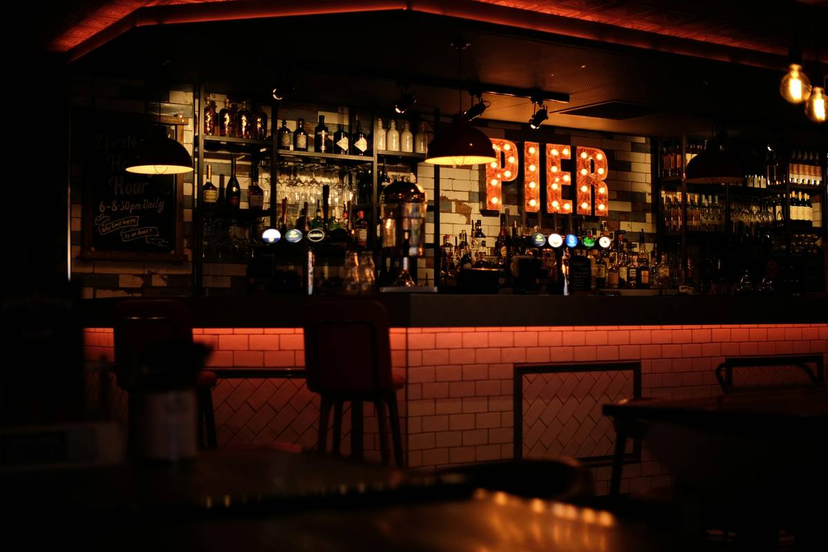 Cozy home bar with warm bar wall lighting ideas using recessed cove lights and dimmed sconces