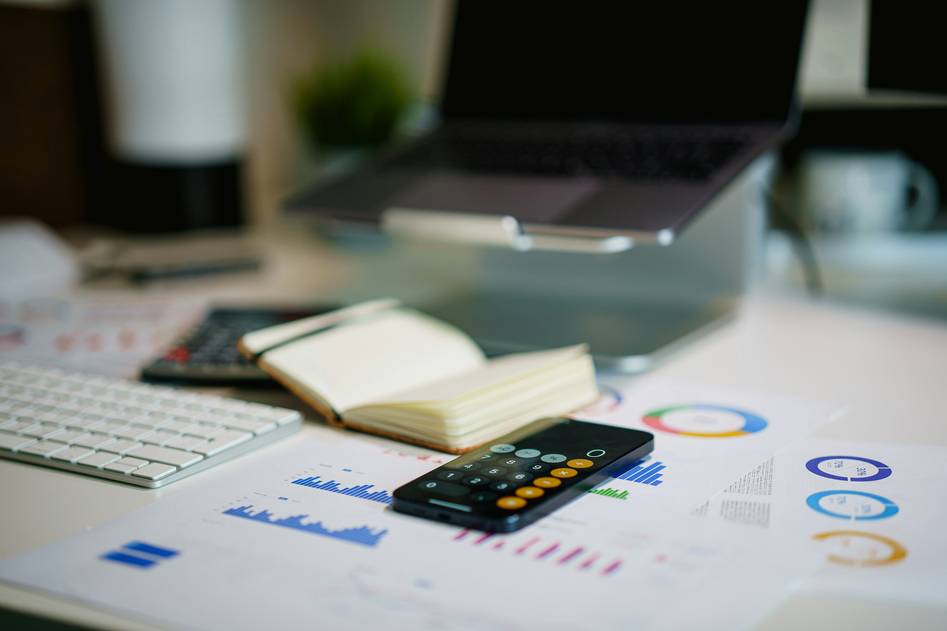 Blogger analyzing insurance documents and credit card statements at a convention planning desk